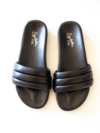 A pair of black slide sandals from Seychelles. They have a molded footbed and the upper is 3 connected puff tubes.